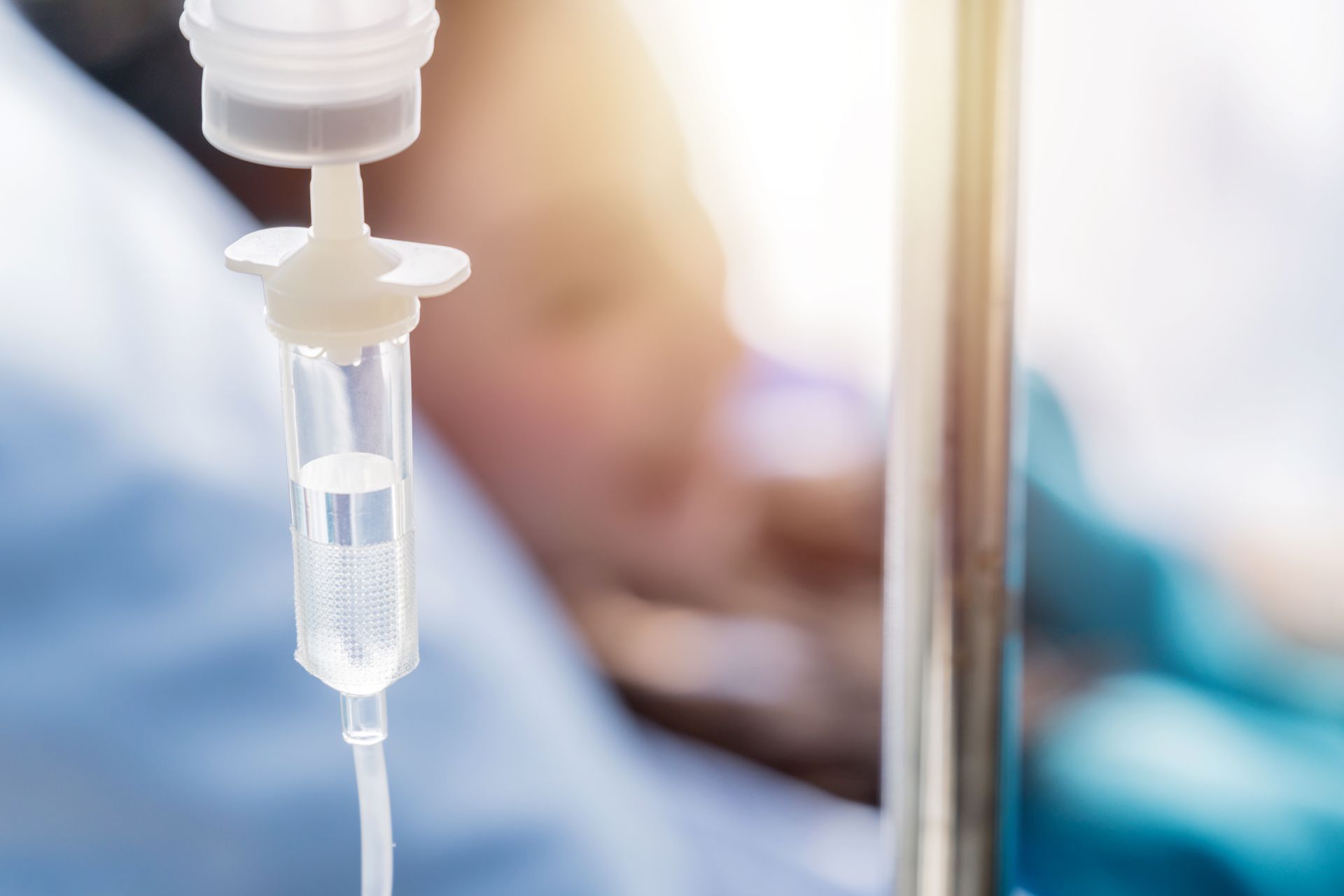 Close-up of an IV drip bag and tubing in a hospital setting