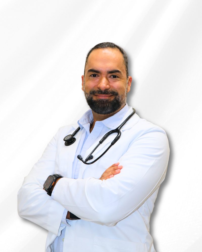 Smiling doctor in a white coat with a stethoscope, arms crossed, against a white background